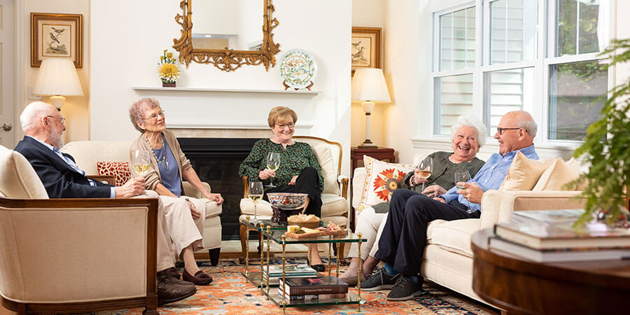 Group of senior friends drinking wine and socializing